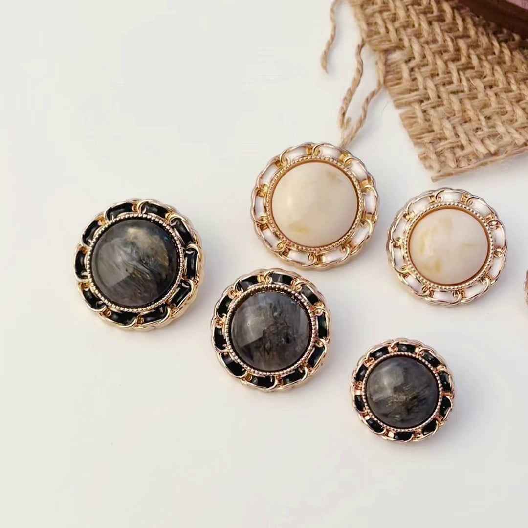 Round resin shank buttons in beige and dark grey, gold-tone frames