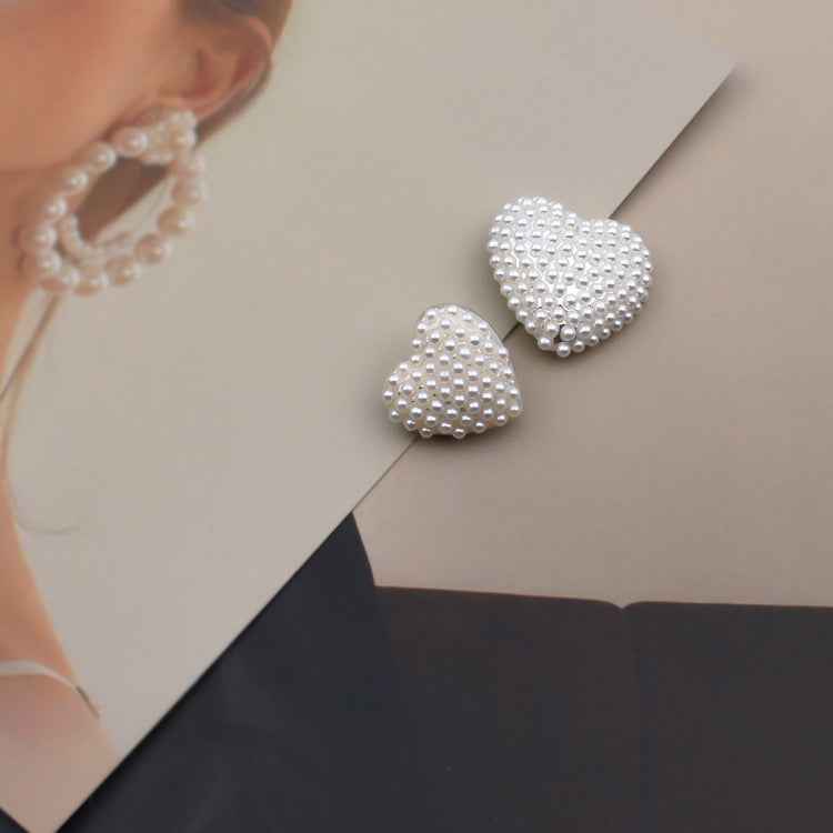 Two heart-shaped faux pearl buttons with rhinestone-like sparkle, flat bead border