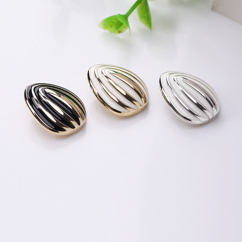 Drei Schalform-Emailleknöpfe: schwarz, gold-weiß und silber-weiß