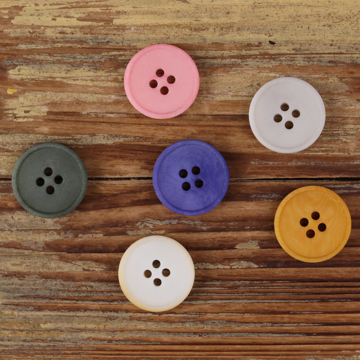 Pink round 4-hole matte natural nut button with four dark holes