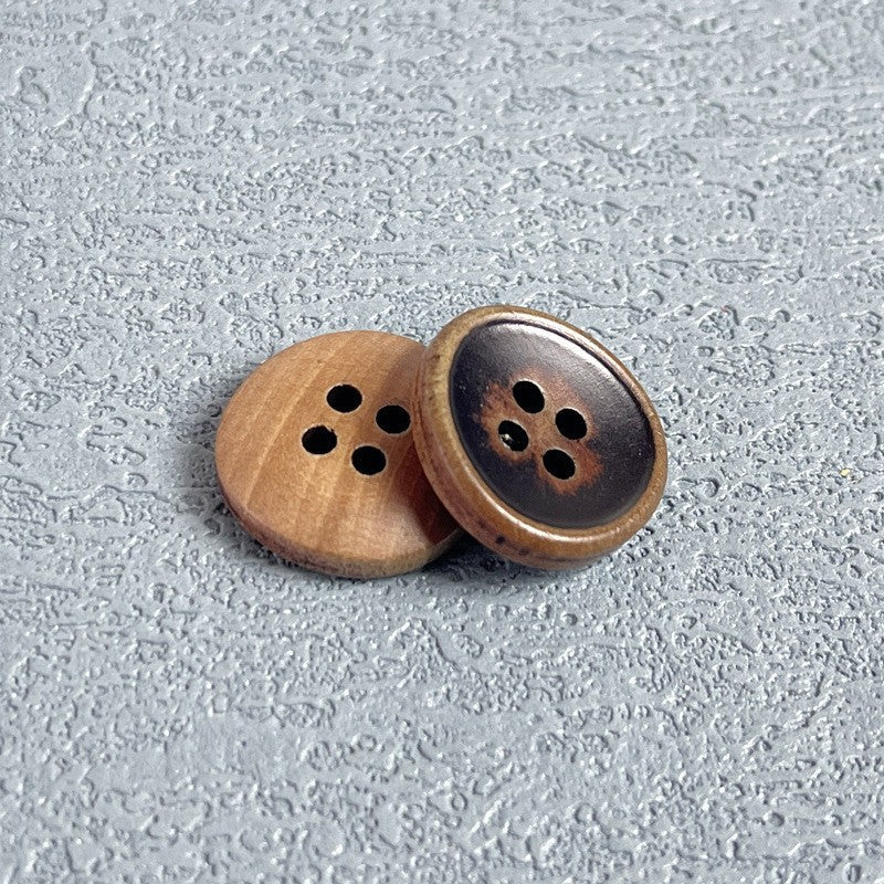 Four-hole wood buttons, brown wood side by side with dark inset faces.