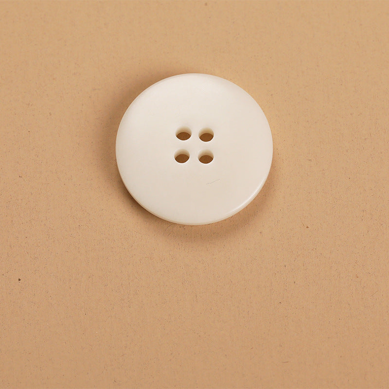 Round 4-hole natural fruit shell button, off-white, single button close-up