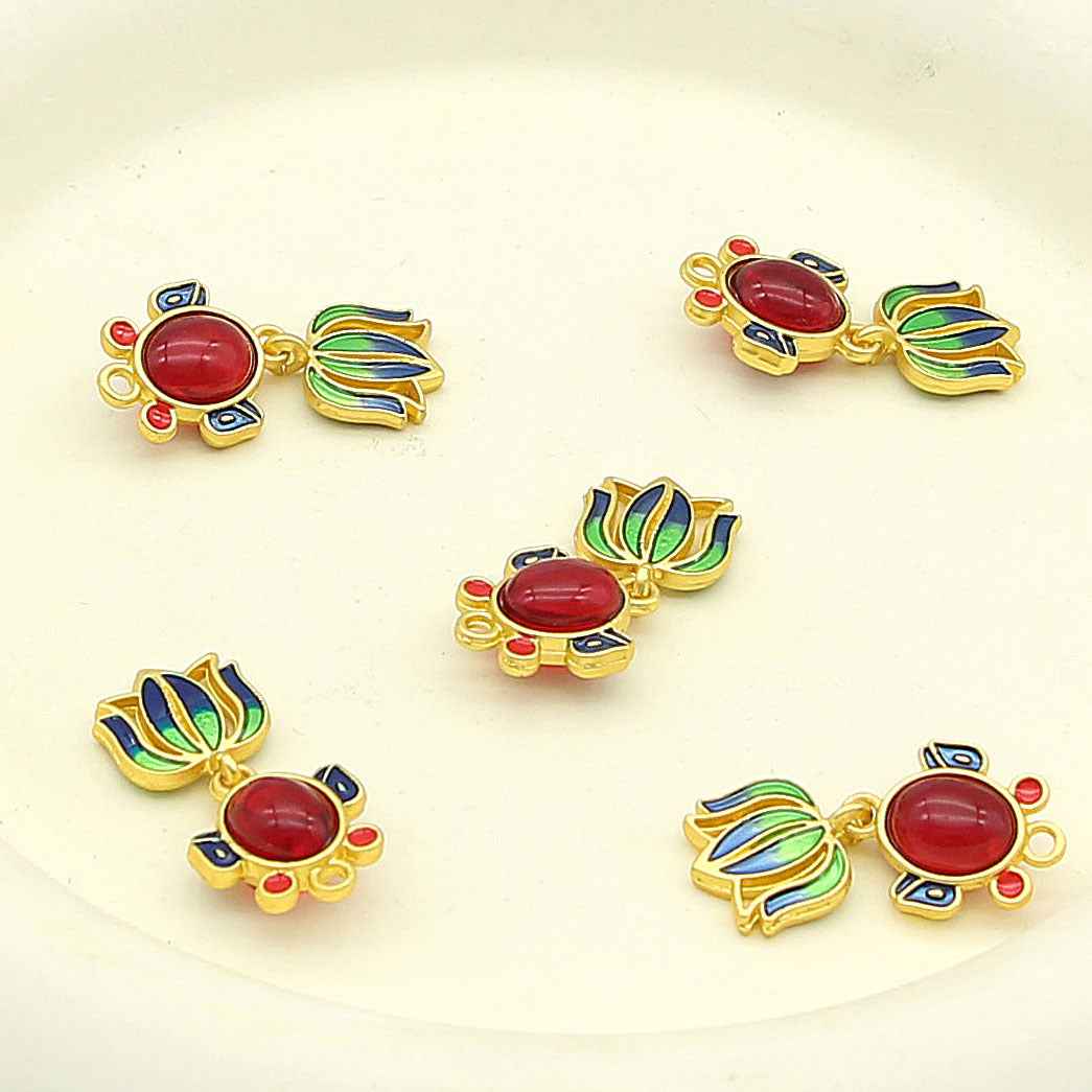 Goldfish-shaped decorative metal button with red oval center, blue/green accents, gold frame