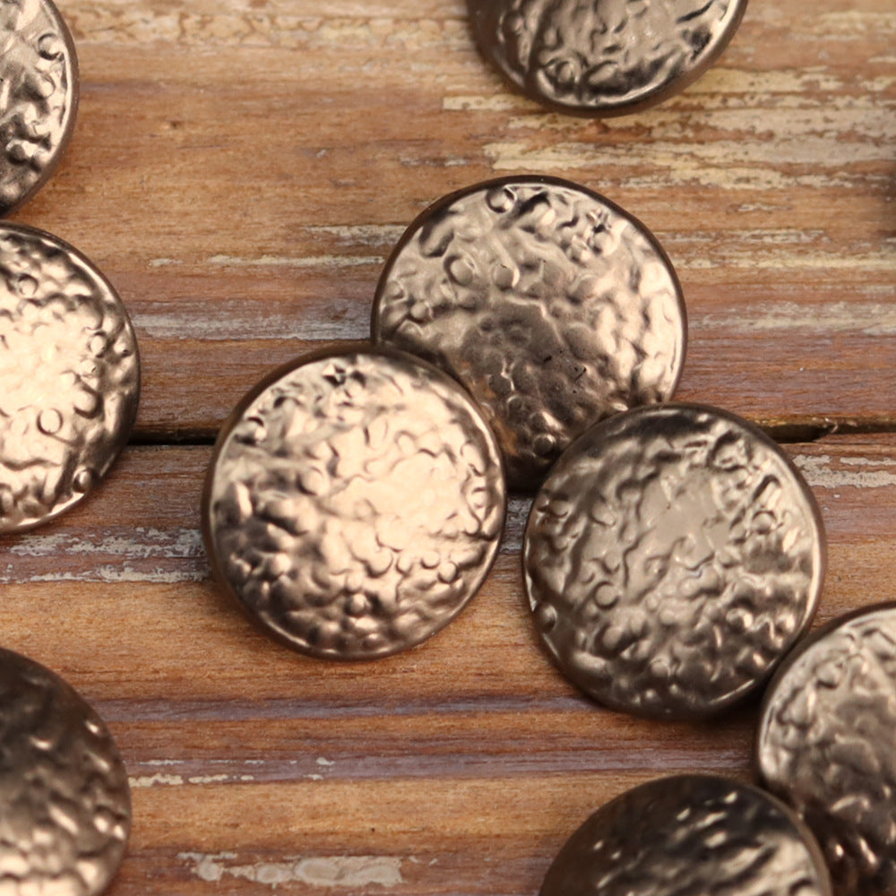 Round metal shank buttons with vintage wave embossing in warm bronze and gold tones.