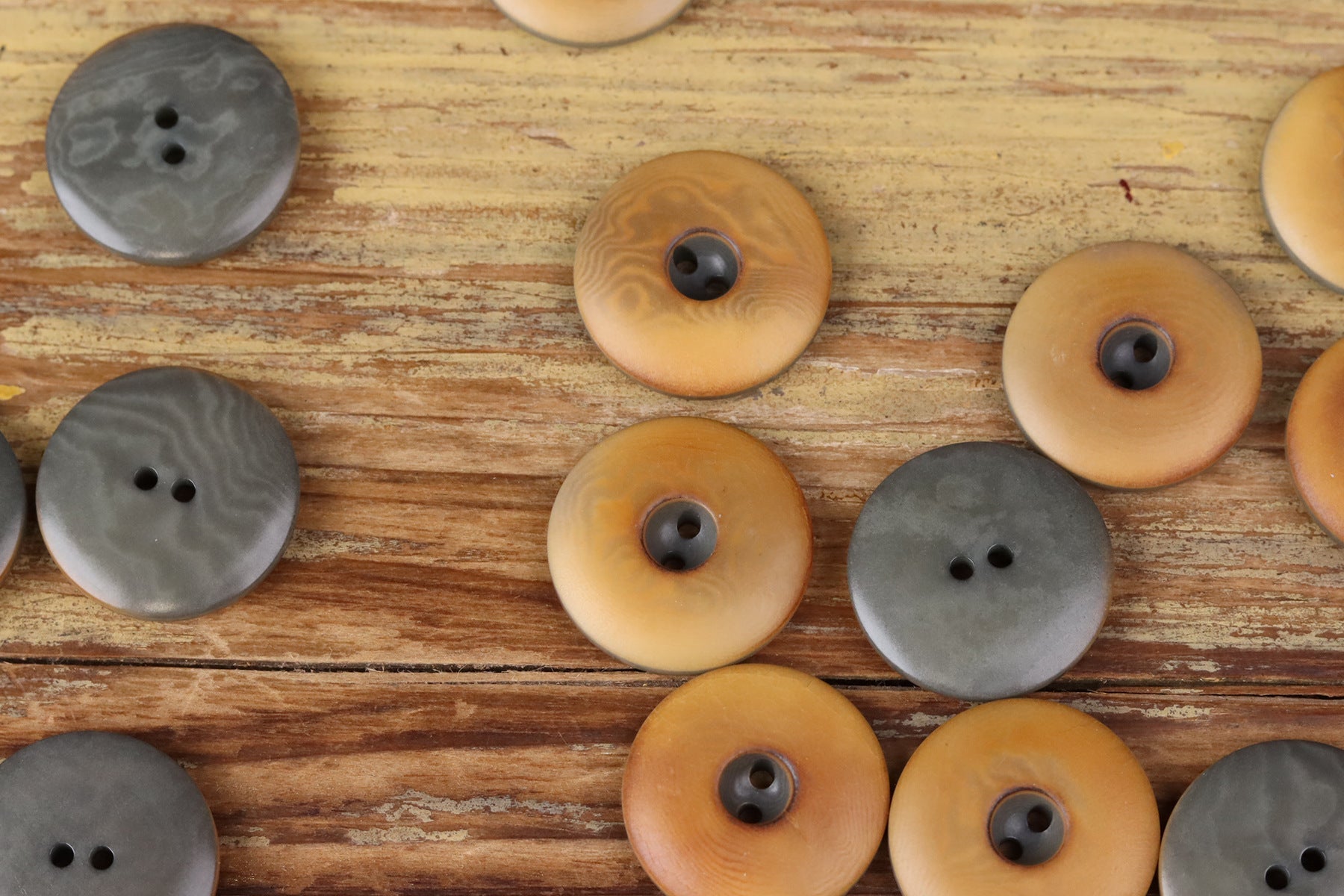 Assorted round two-hole seed buttons in grey, tan, and light brown