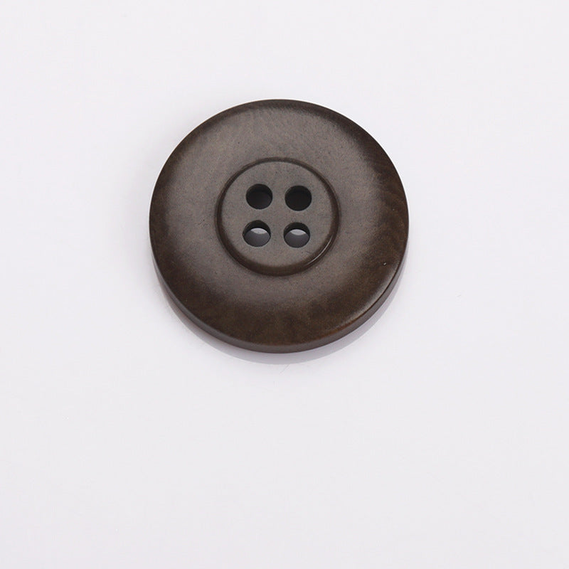 Dark coffee-brown round sewing button with four holes and subtle rim