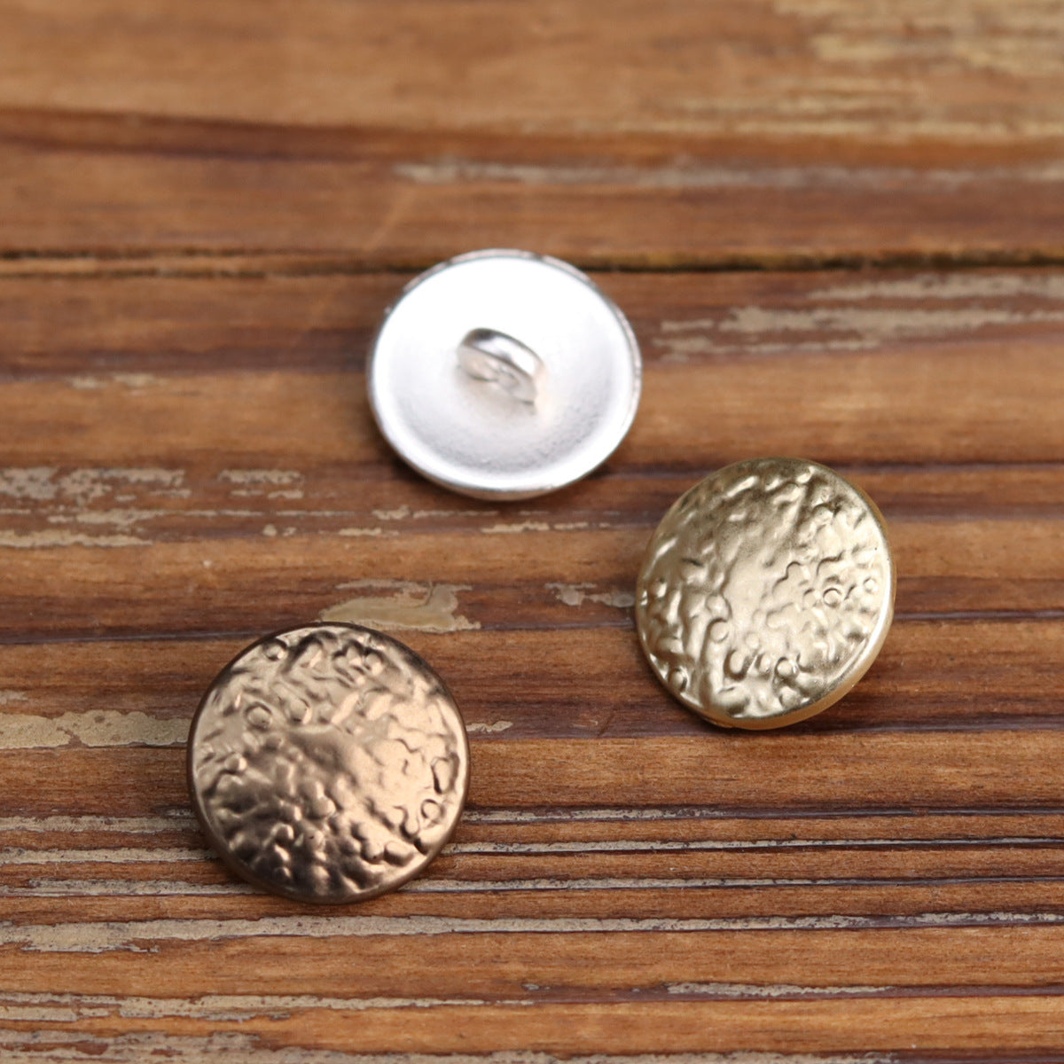 Round metal shank buttons with vintage wave embossing; silver, gold, and bronze tones.