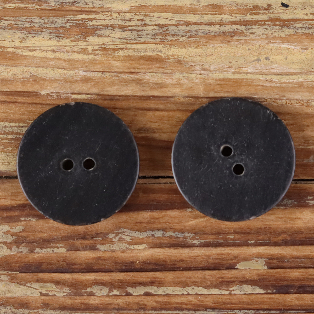 Handmade horn button pair, dark round backs with two holes each