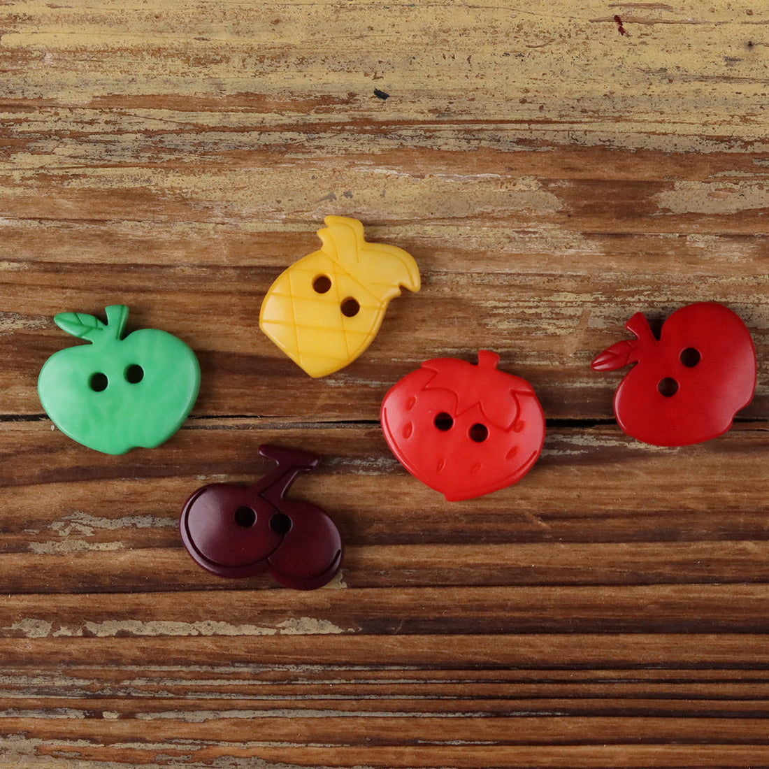 Fruit-shaped corozo buttons, red, green, yellow, and dark purple, assorted designs