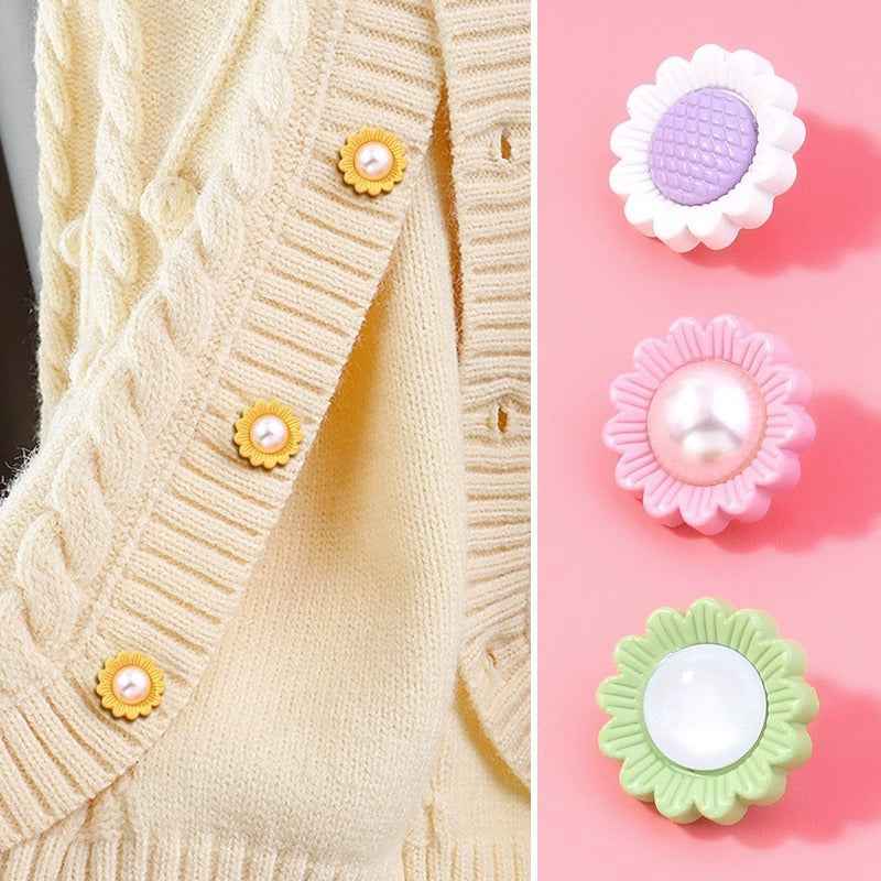 Cream knit fabric with small gold sunflower resin shank buttons and pearl centers