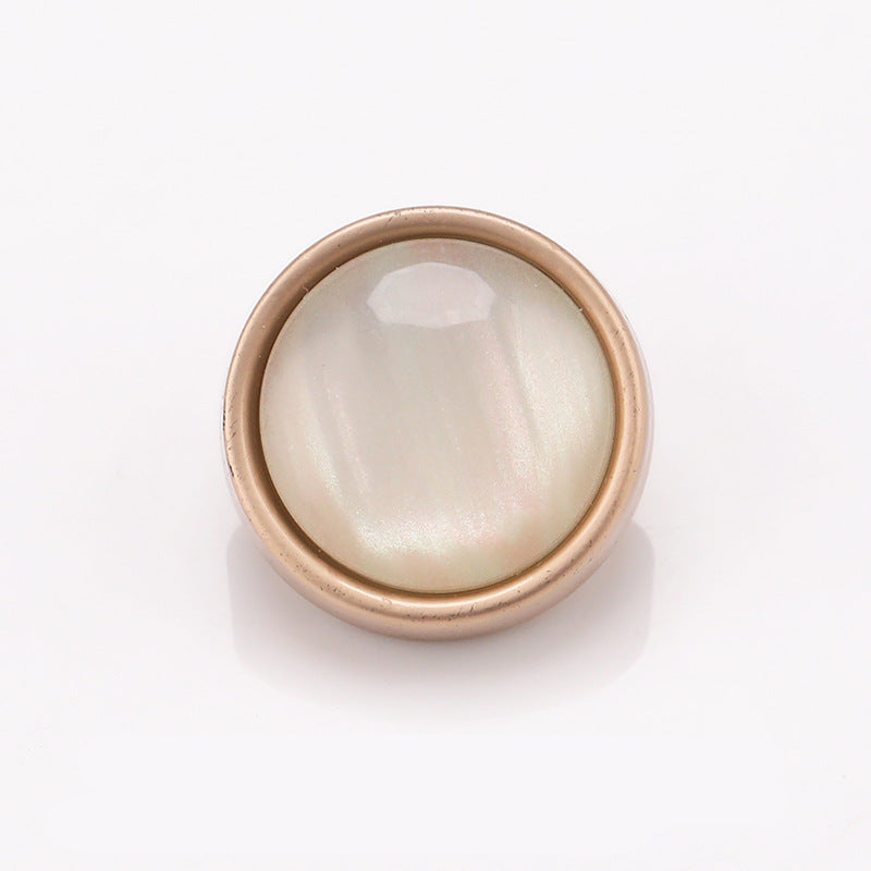 Cat-eye stone button with metal frame, matte gold rim and pearly white center