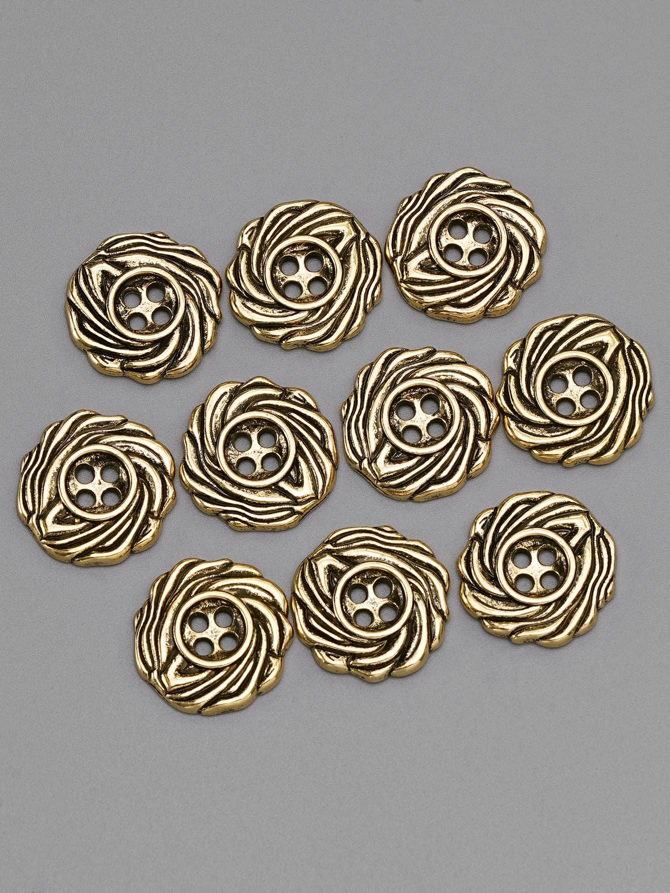 Gold tone 4-hole spiral metal buttons, multiple pieces arranged, front view