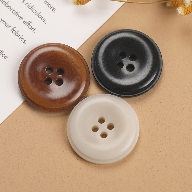 Three round 4-hole natural fruit shell buttons in brown, black, and off-white