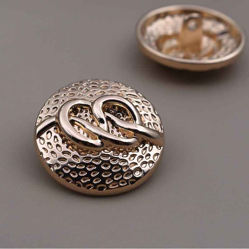 Round antique metal coat buttons with decorative swirl pattern and shank, light gold