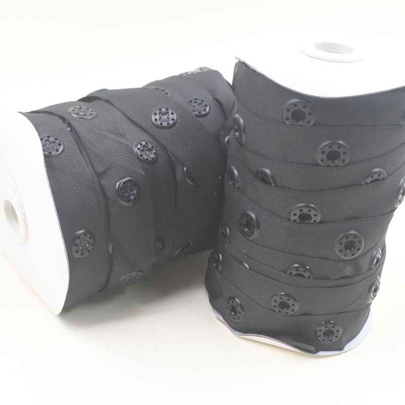 Black snap fastener button tape roll, fabric strip with evenly spaced snap buttons