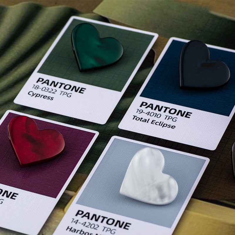 Heart buttons placed on color cards; dark green, navy, burgundy, and white visible