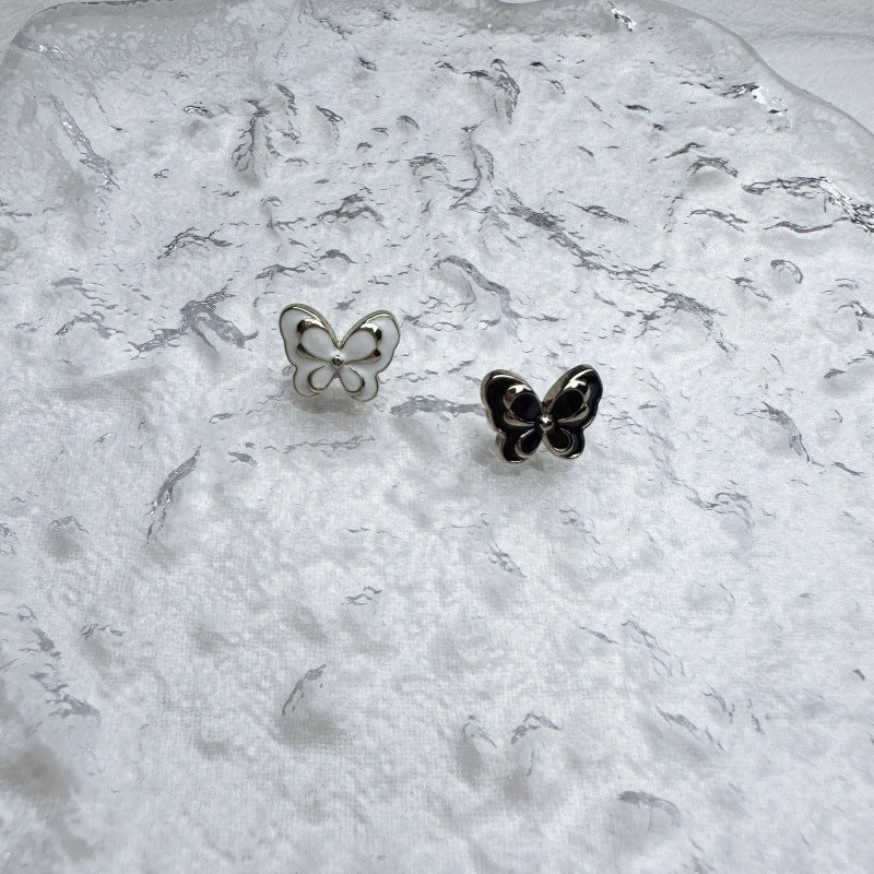 Butterfly metal buttons in black and white enamel, with gold-toned back loops