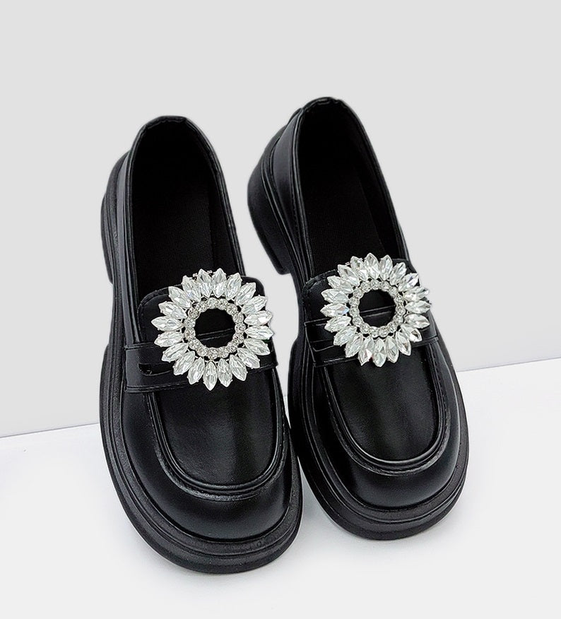 Detachable rhinestone sunflower shoe buckles on black loafers' front straps