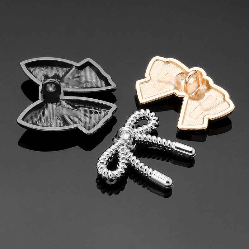 Assorted bow tie metal buttons with glossy black and silver-toned finishes