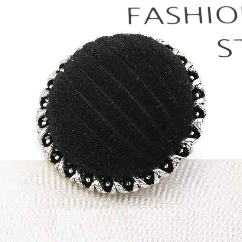 Black velvet-wrapped metal button, lace-edged scalloped rim, textured center