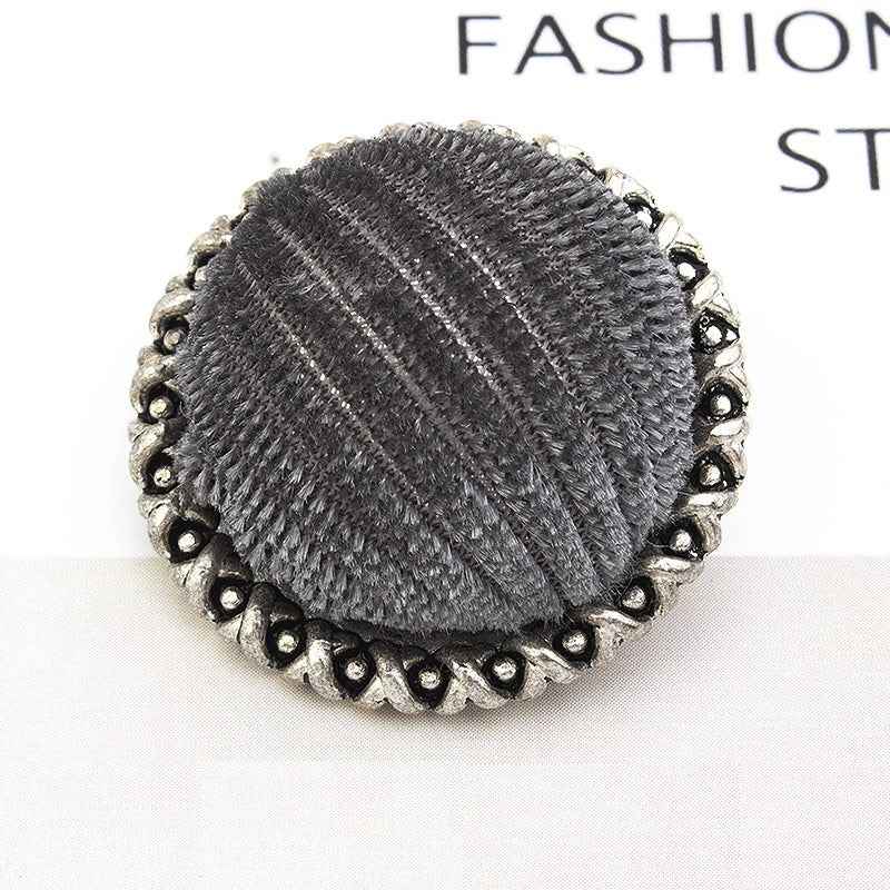 Black velvet-wrapped metal button, lace-edged scalloped rim, textured center
