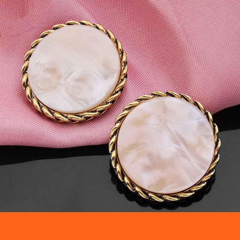 Two round resin buttons with gold braided edge and pale white/pink marbled faces