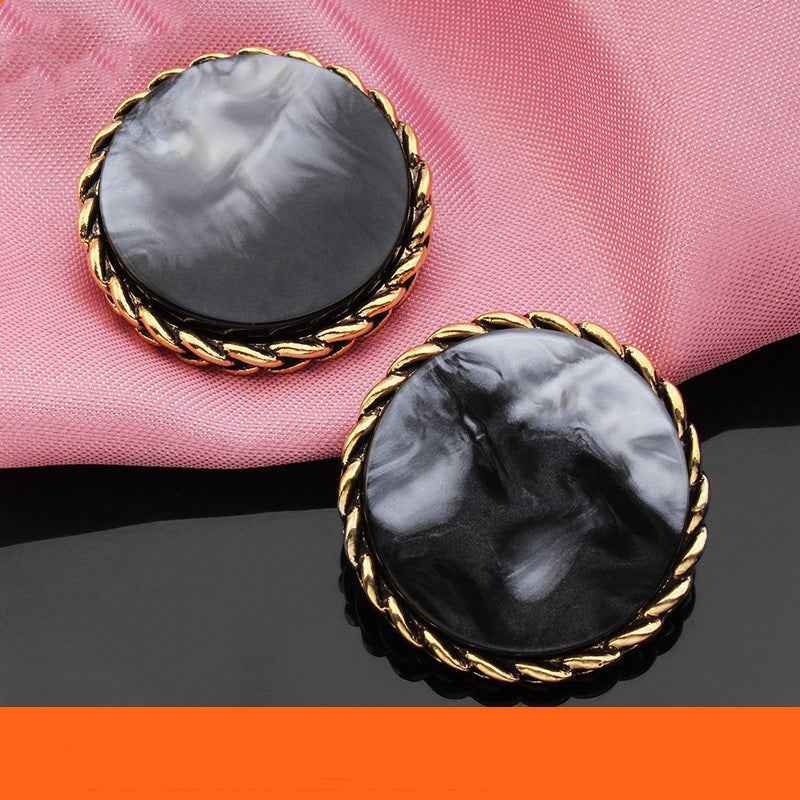 Two dark gray round resin buttons with gold braided edge, marbled resin surface