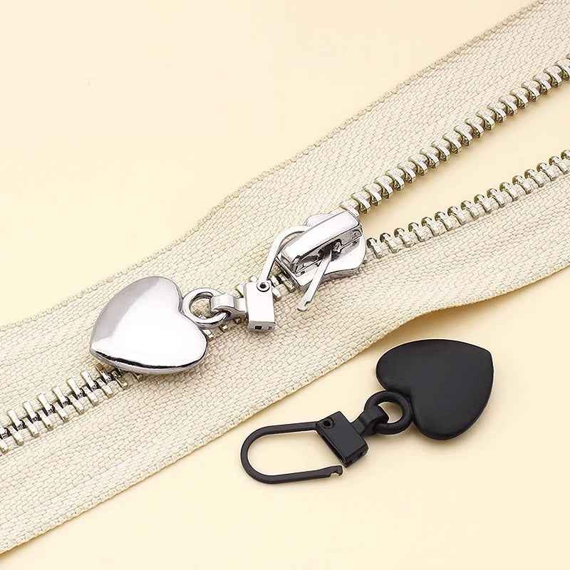 Silver and black heart zipper pulls on zipper with metal clip latch