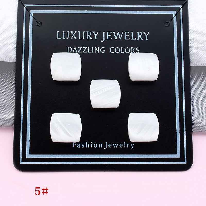 White rounded-rectangular magnetic collar clips on a display card, five pieces