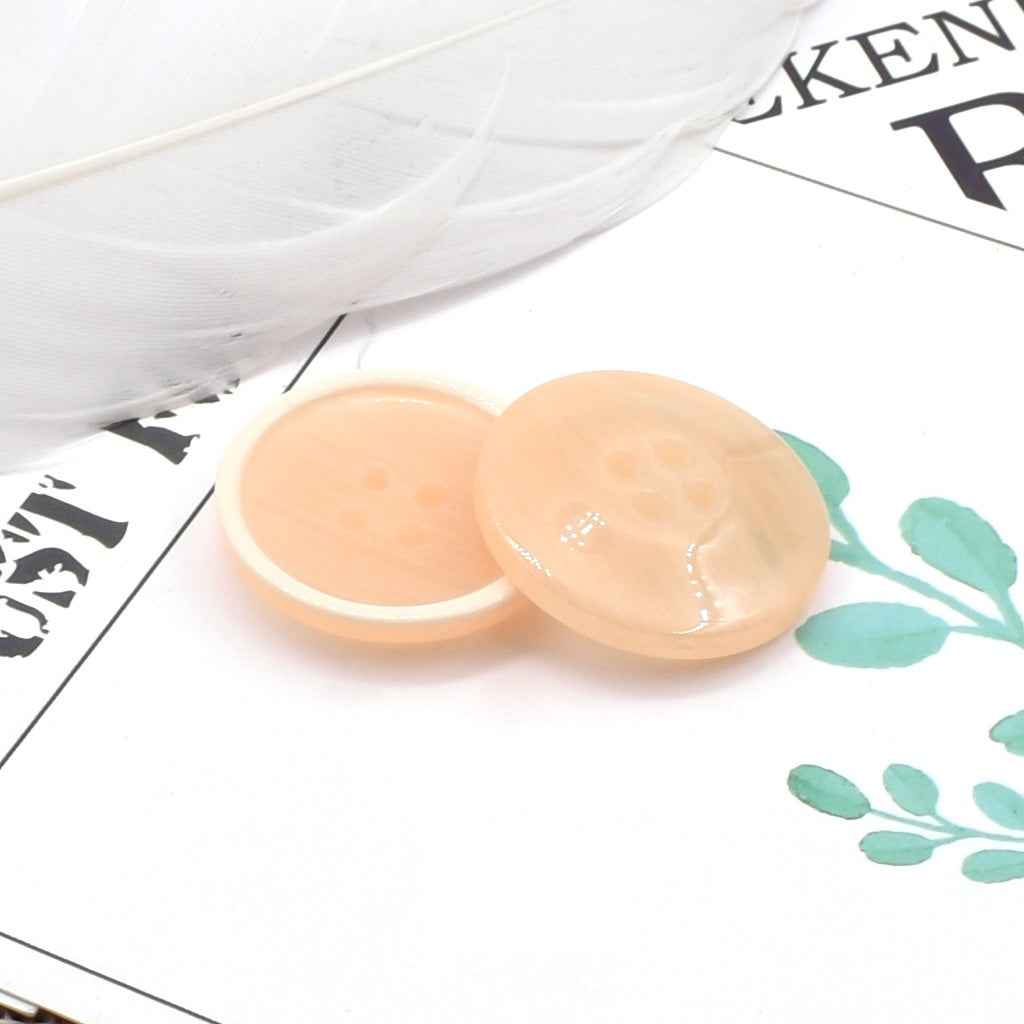 Round 4-hole peach resin coat buttons with pearl-look edge detail