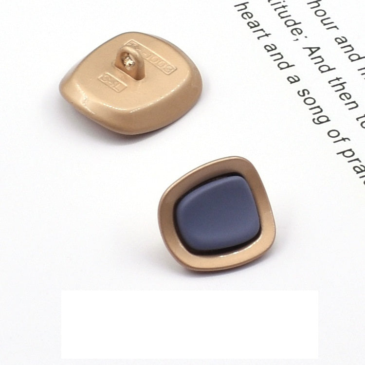 Square concave metal shank button, dark blue front with gold-tone frame