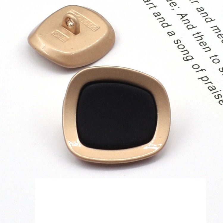 Square concave metal shank button, black front with gold-tone frame
