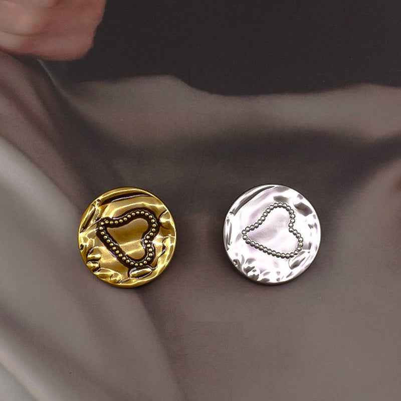 Two metal shank buttons: gold and silver heart motifs with bead detail