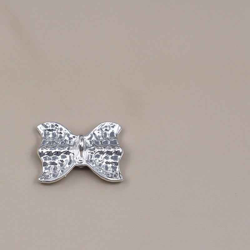Silver rhinestone bow shank button, back view with smooth metal setting