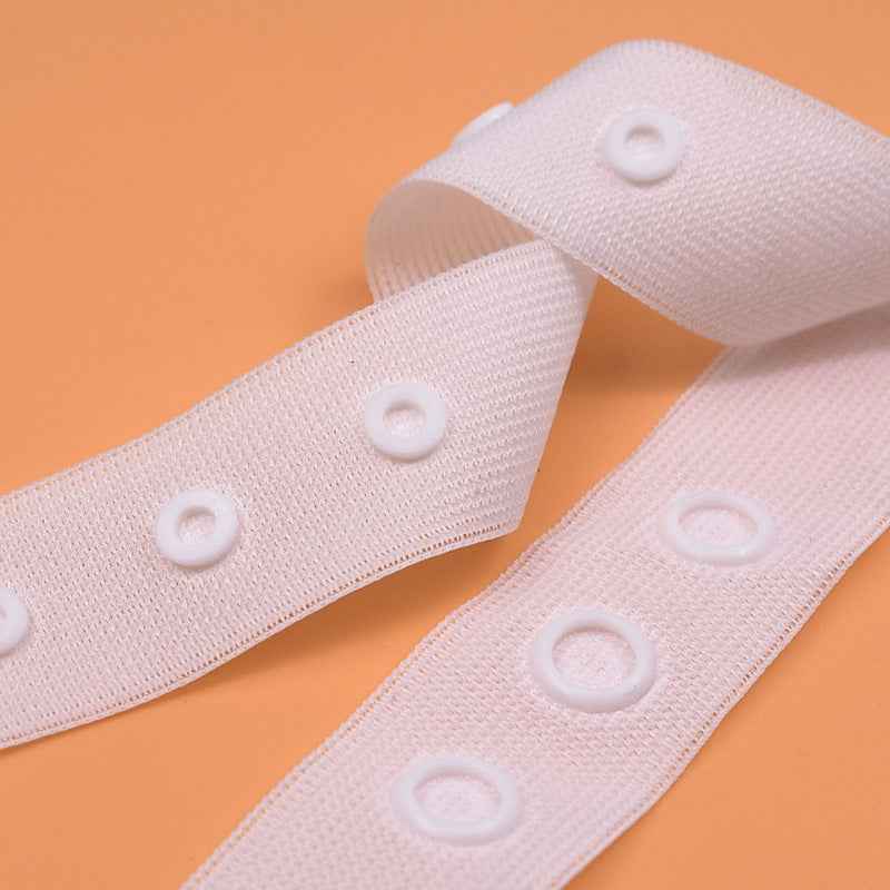White sewing snap fastener tape strip with round snap buttons, spaced closures