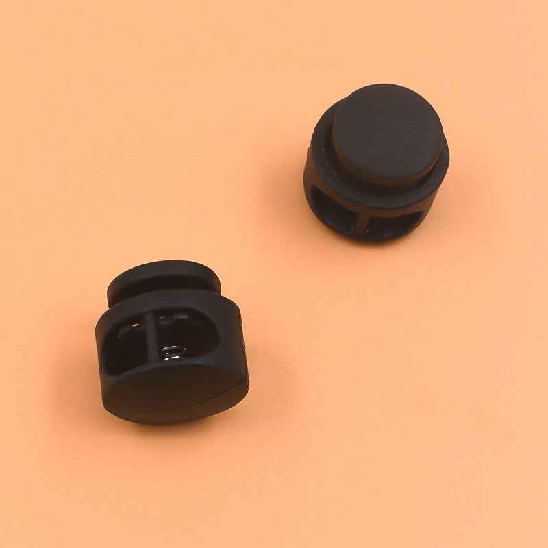 Two black plastic cord locks with round tops and side release edges