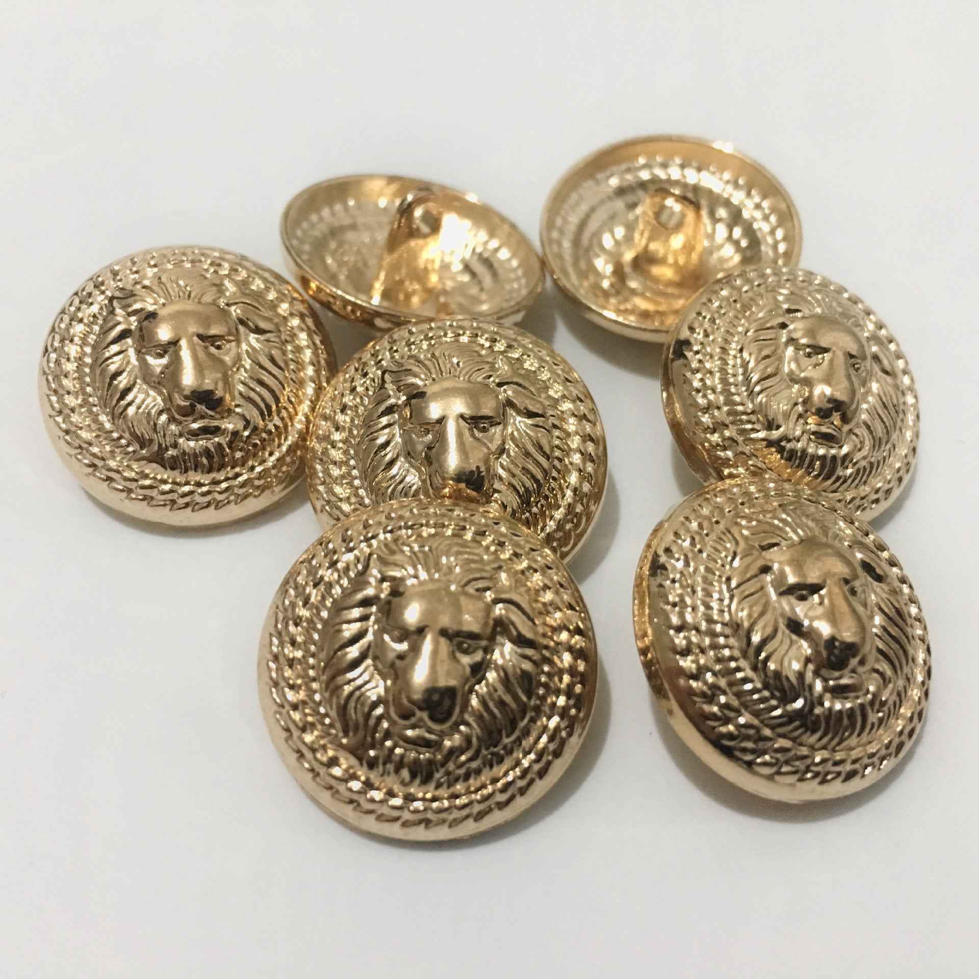 Gold lion head metal shank buttons, round faces with raised mane design