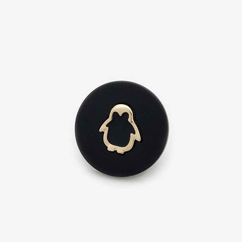 Beige resin shank button with gold penguin outline
