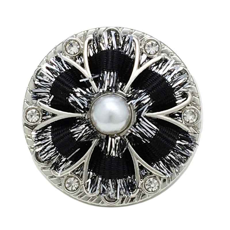 Close-up black floral shank button with pearl center, silver frame and rhinestone border