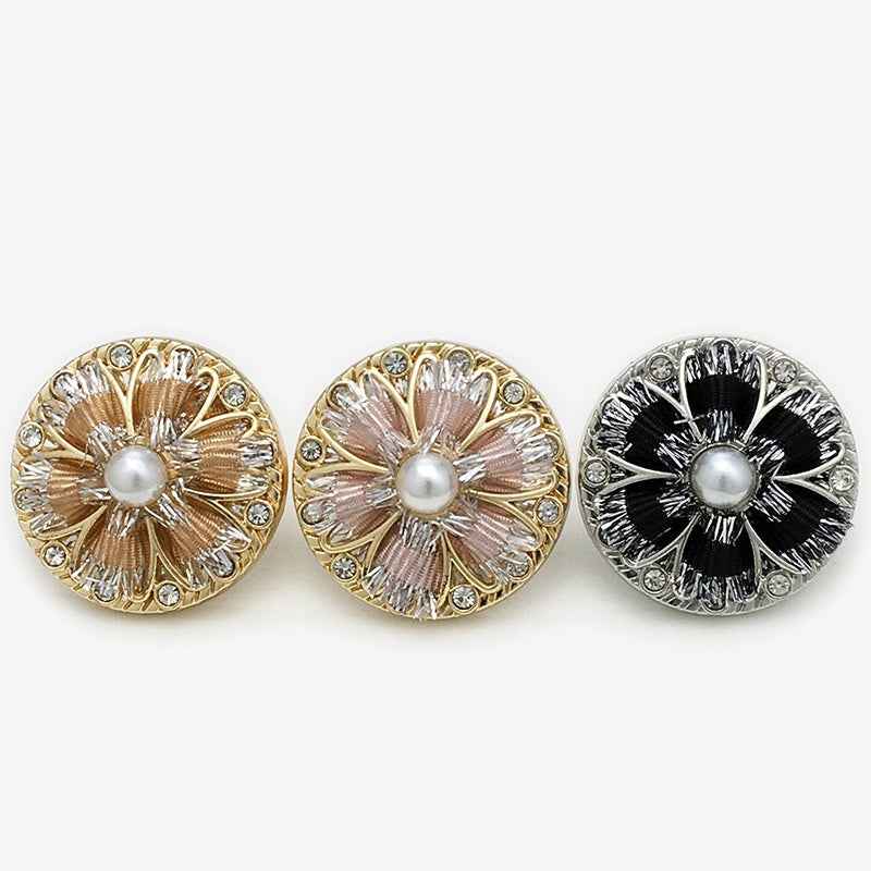 Three floral shank buttons in pink, champagne, and black with pearl centers and rhinestones