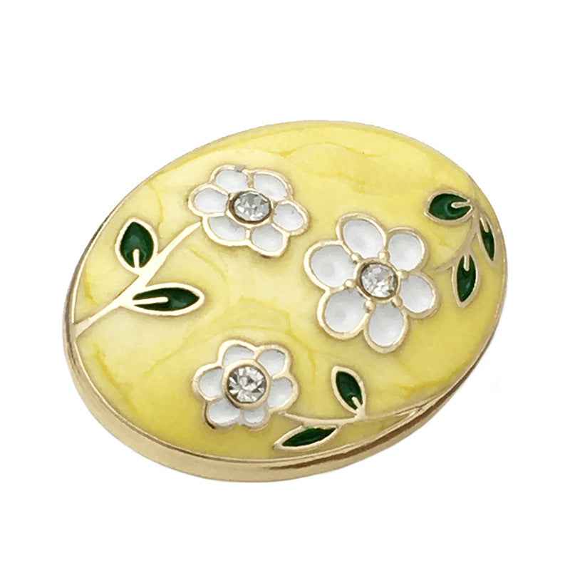 Oval floral enamel metal button, yellow front with white flowers, green leaves, gold outline