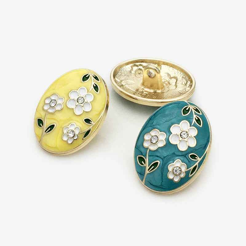 Oval floral enamel buttons: yellow and teal fronts with gold-tone backs