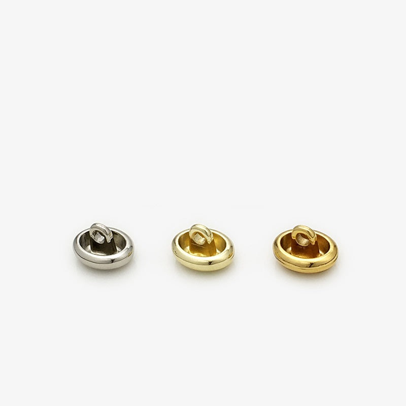 Back view of glossy oval metal shirt buttons, gold and silver; 11mm, hand-sewn