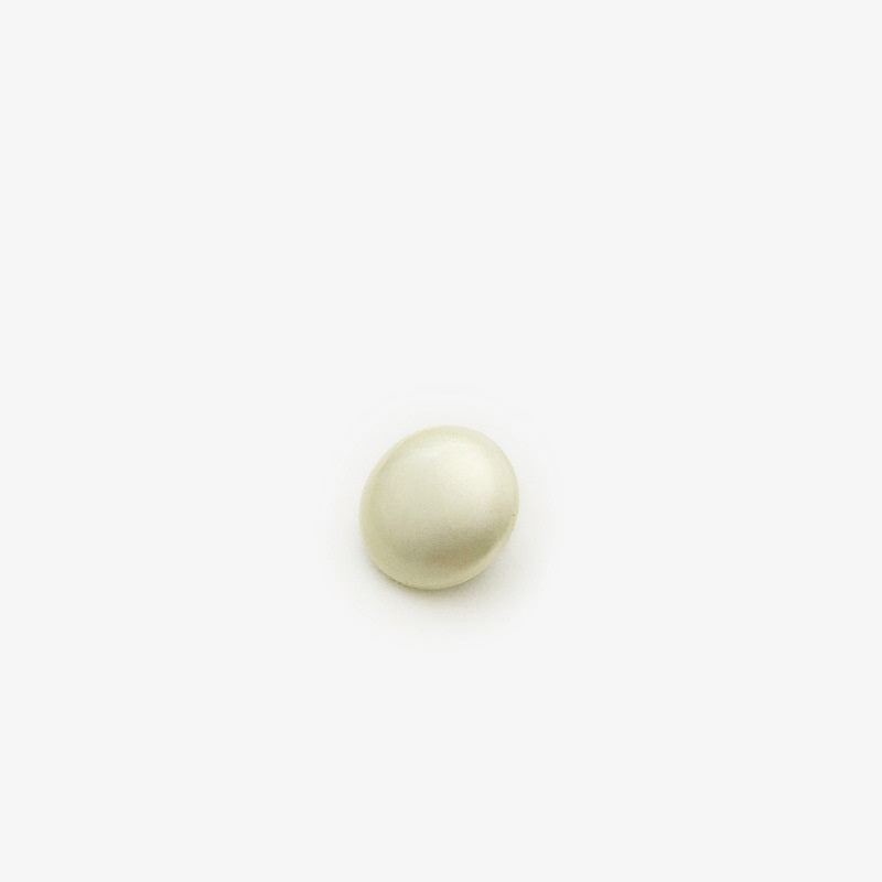 Light yellow pearl sew-on button with metal backing for blouses, close-up