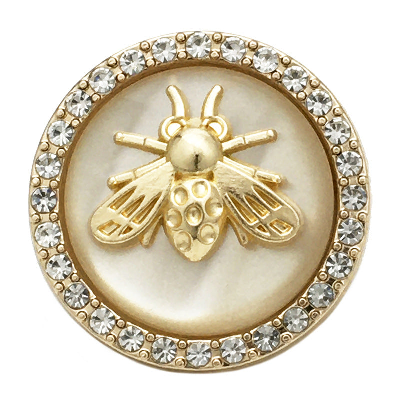 Bee coat button close-up, beige two-tone resin, gold bee detail with rhinestone rim
